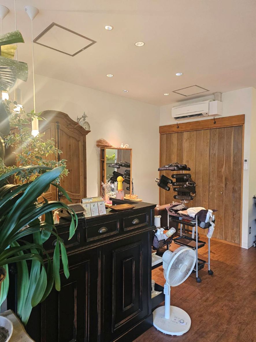 olu pono HAIR MAKEの店内。木製の家具や扉、観葉植物のある空間